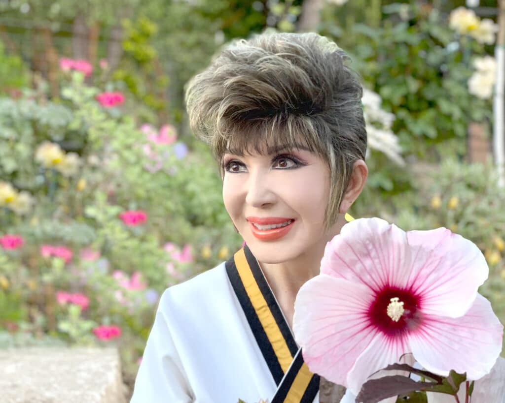 Dr Tae Yun Kim smiling holding a flower